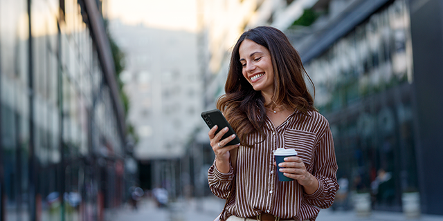 Eine Frau hat die Allianz App auf einem Smartphone geöffnet, zur digitalen Verwaltung von Versicherungen und Schäden.